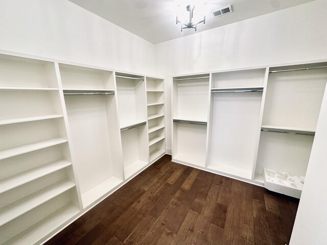 walk in closet with dark wood finished floors and visible vents