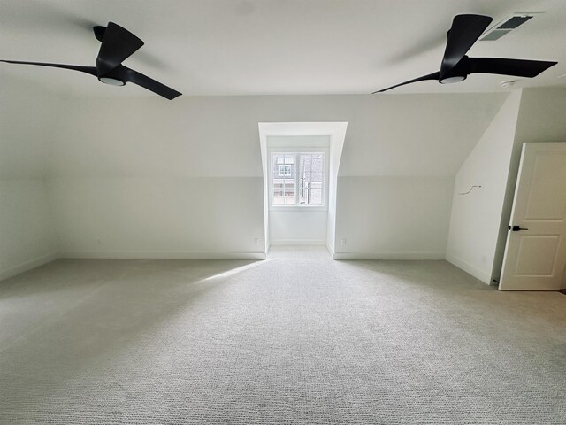 additional living space with light colored carpet, a ceiling fan, visible vents, and baseboards