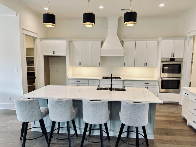 kitchen with custom exhaust hood, double oven, and ornamental molding