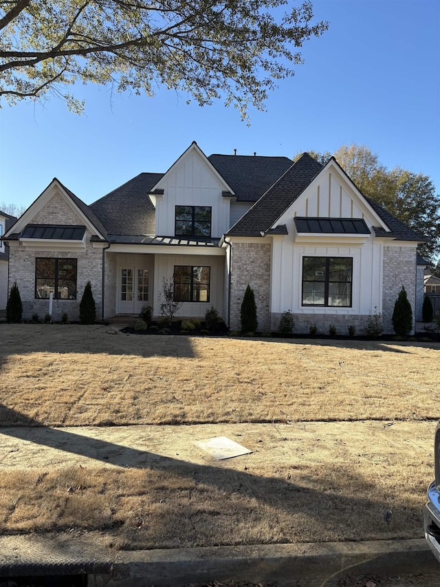 modern inspired farmhouse with a standing seam roof, french doors, board and batten siding, and metal roof