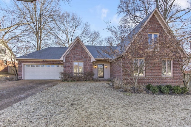 view of front of property featuring an attached garage, driveway, and brick siding