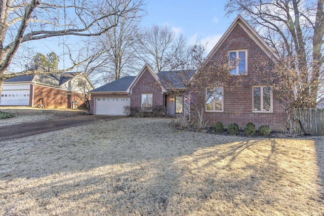 view of front of home featuring driveway, brick siding, and an attached garage