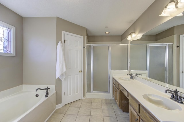 bathroom featuring double vanity, a stall shower, a sink, and tile patterned floors