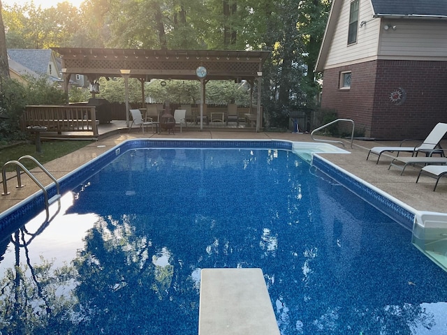 outdoor pool featuring a diving board, a patio area, and a pergola