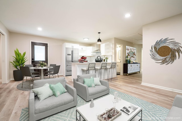 living area featuring recessed lighting, light wood-type flooring, attic access, and baseboards