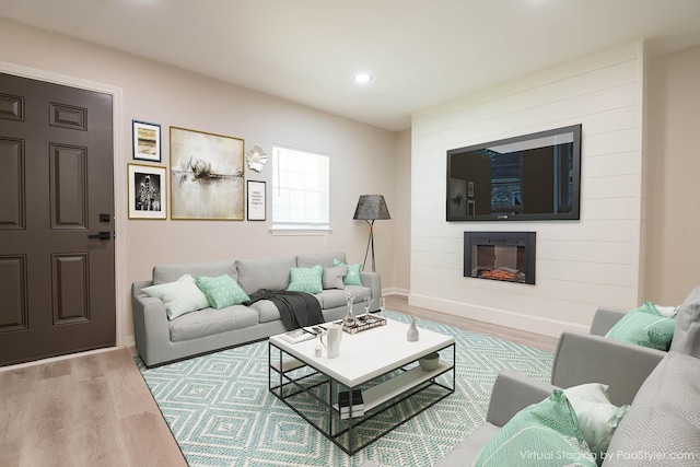 living room featuring a fireplace, baseboards, wood finished floors, and recessed lighting