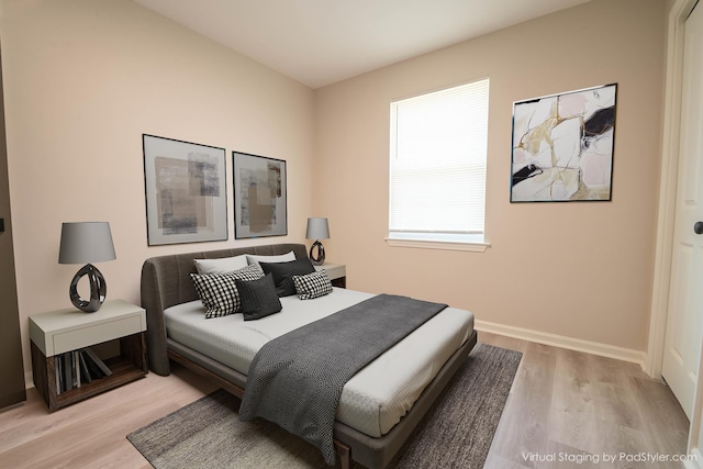 bedroom featuring wood finished floors and baseboards