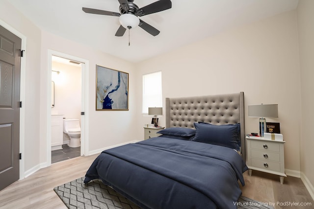 bedroom with ceiling fan, connected bathroom, baseboards, and wood finished floors