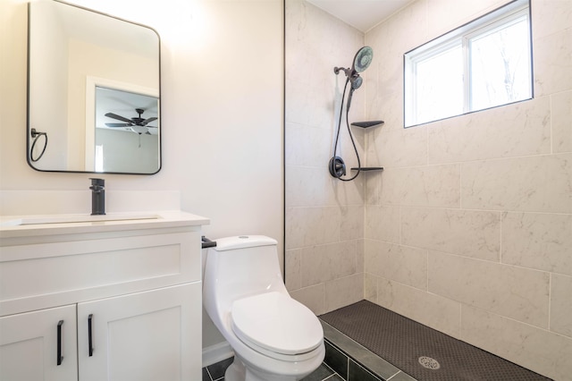 full bathroom featuring toilet, tiled shower, and vanity