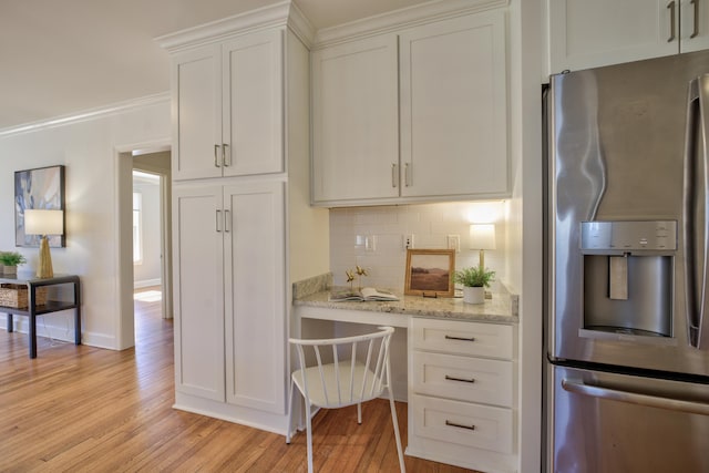 kitchen with backsplash, light wood-style floors, ornamental molding, white cabinets, and stainless steel fridge with ice dispenser