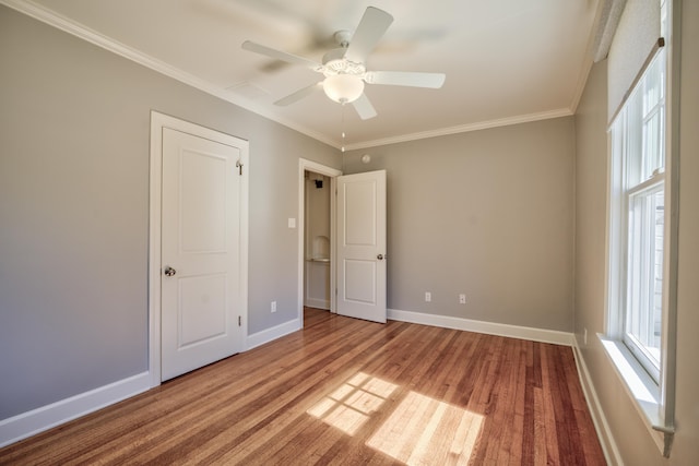 unfurnished bedroom with crown molding, baseboards, ceiling fan, and wood finished floors