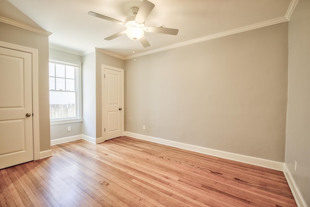 empty room featuring ornamental molding, light wood-type flooring, ceiling fan, and baseboards