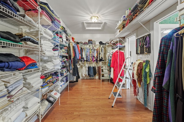 spacious closet featuring wood finished floors and attic access