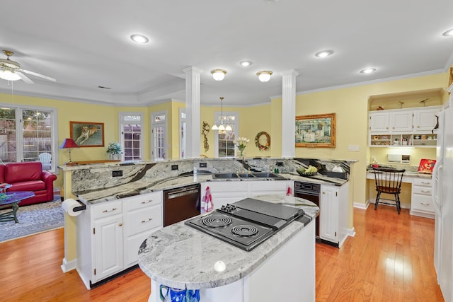 kitchen featuring a peninsula, a sink, dishwasher, decorative columns, and crown molding