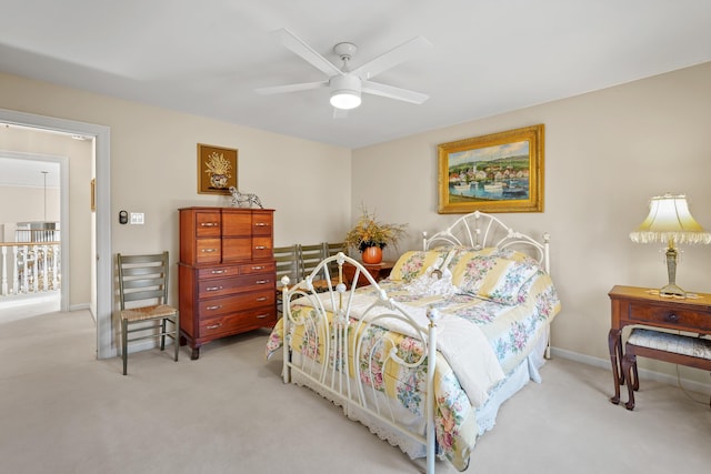 bedroom with light colored carpet, ceiling fan, and baseboards