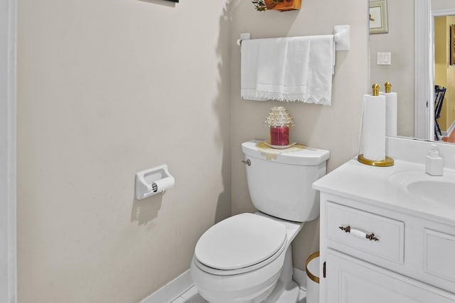 bathroom featuring baseboards, vanity, and toilet