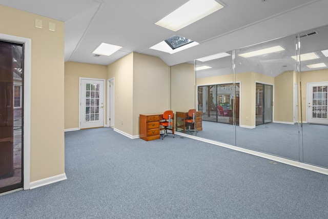 interior space with carpet floors, visible vents, baseboards, and vaulted ceiling