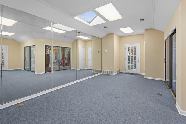 spare room with lofted ceiling with skylight, visible vents, and baseboards