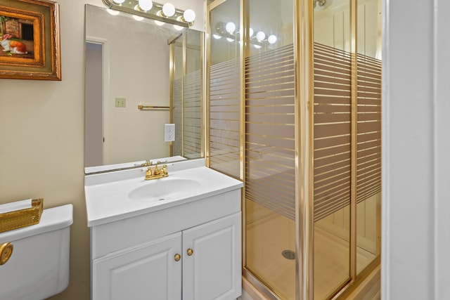 full bath featuring toilet, a stall shower, and vanity