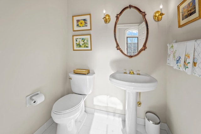 bathroom featuring tile patterned flooring, toilet, and baseboards