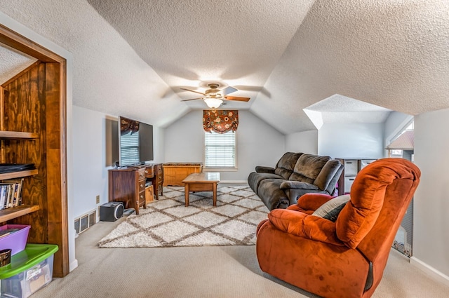 sitting room featuring ceiling fan, a textured ceiling, visible vents, vaulted ceiling, and carpet