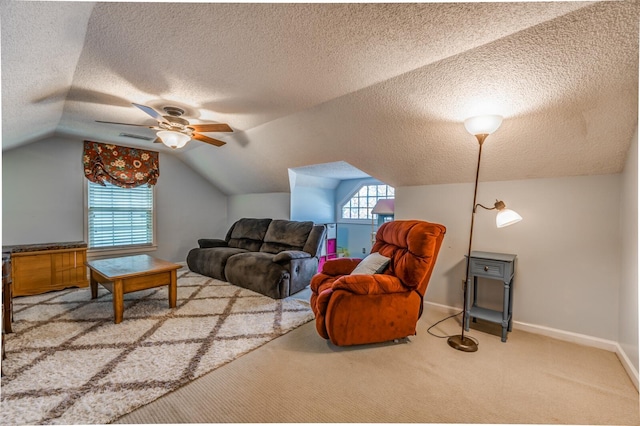 carpeted living area featuring lofted ceiling, ceiling fan, a wealth of natural light, and baseboards