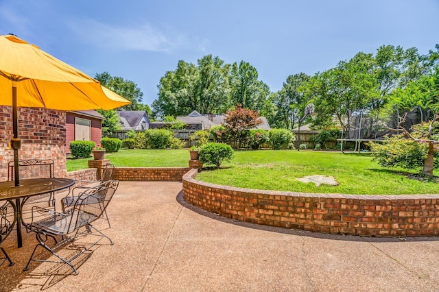 view of patio featuring a trampoline and fence