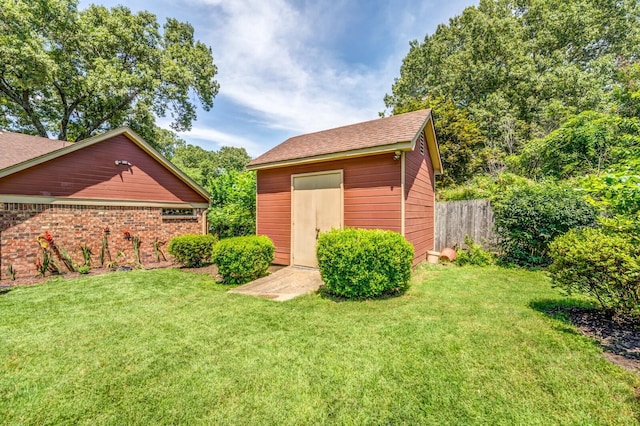 view of yard with an outdoor structure, a storage shed, and fence