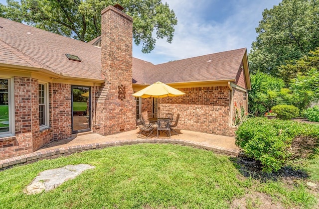 back of property with brick siding, a chimney, and roof with shingles