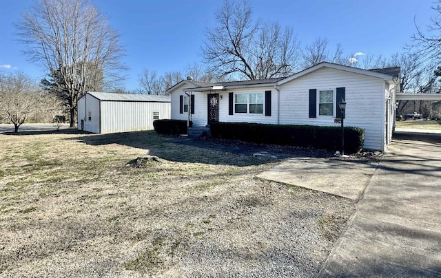 view of front of property featuring driveway and an outdoor structure