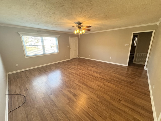 spare room with ornamental molding, wood finished floors, and baseboards