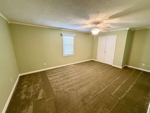 unfurnished bedroom with dark colored carpet, crown molding, and baseboards