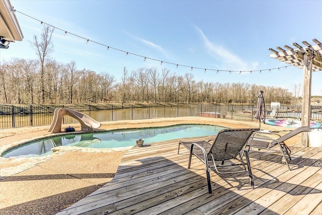 view of swimming pool with a fenced in pool, a water slide, fence, and a deck