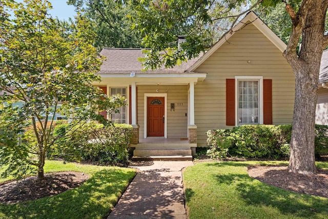 view of front of house with a front yard and roof with shingles