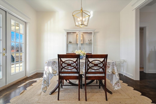 dining area with a chandelier, wood finished floors, and baseboards