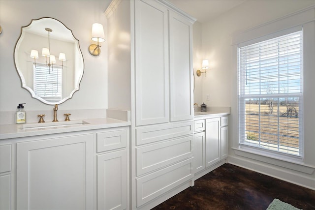 bathroom with double vanity, a sink, and an inviting chandelier