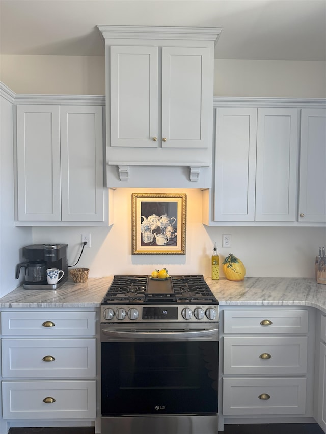 kitchen featuring light stone countertops, white cabinets, and stainless steel range with gas stovetop