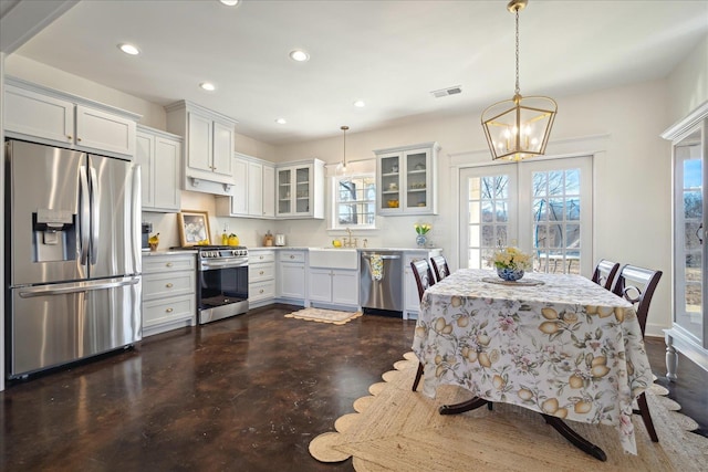 kitchen with recessed lighting, light countertops, appliances with stainless steel finishes, hanging light fixtures, and glass insert cabinets