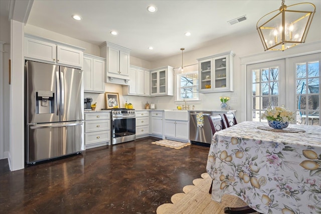 kitchen featuring recessed lighting, light countertops, visible vents, appliances with stainless steel finishes, and glass insert cabinets