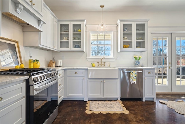 kitchen with appliances with stainless steel finishes, glass insert cabinets, a sink, and custom exhaust hood