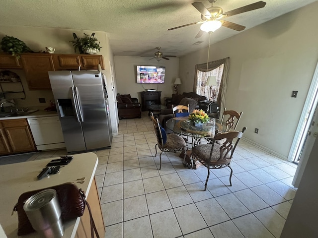 dining space with light tile patterned floors, a textured ceiling, vaulted ceiling, and a ceiling fan