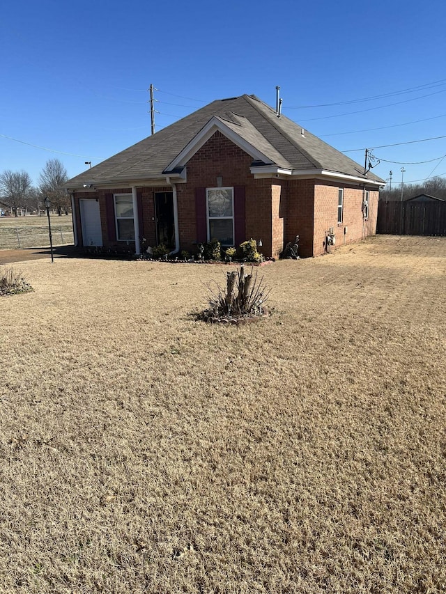 view of front of home with an attached garage, fence, and brick siding