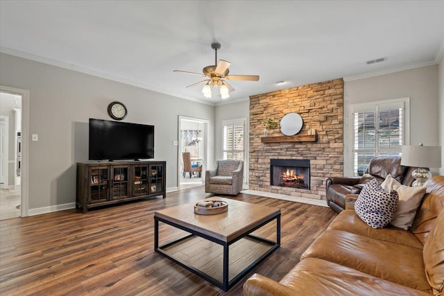 living room featuring baseboards, visible vents, ornamental molding, wood finished floors, and a fireplace