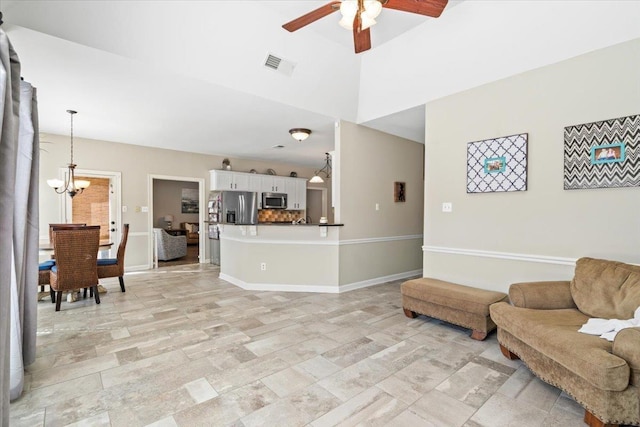 living room featuring ceiling fan with notable chandelier, visible vents, and baseboards