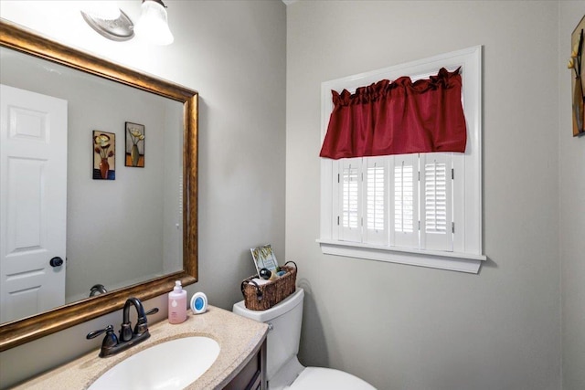 half bath featuring toilet and vanity