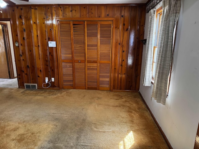 interior space with wood walls, carpet, and visible vents