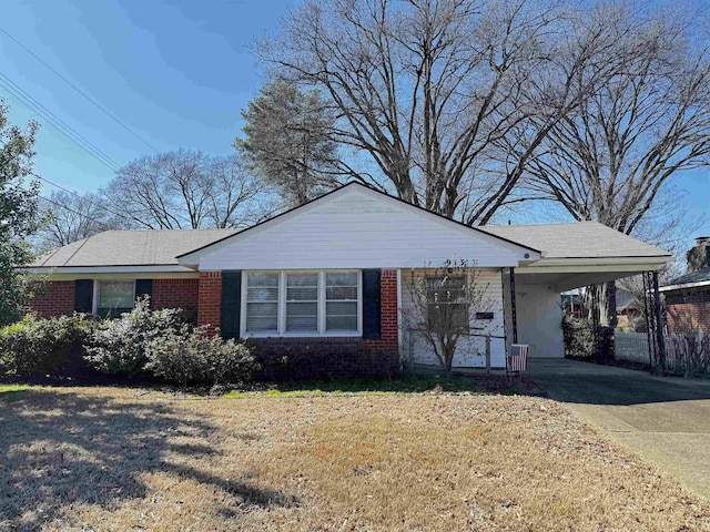 single story home with driveway, a front yard, an attached carport, and brick siding