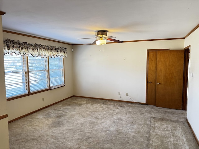 unfurnished room featuring carpet, ornamental molding, ceiling fan, and baseboards