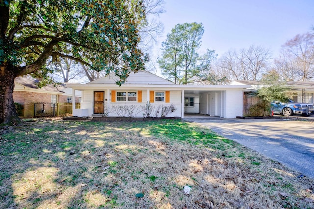 ranch-style house featuring driveway, a porch, fence, and an attached carport