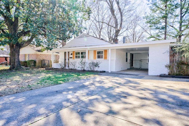 single story home featuring a carport, driveway, brick siding, and covered porch